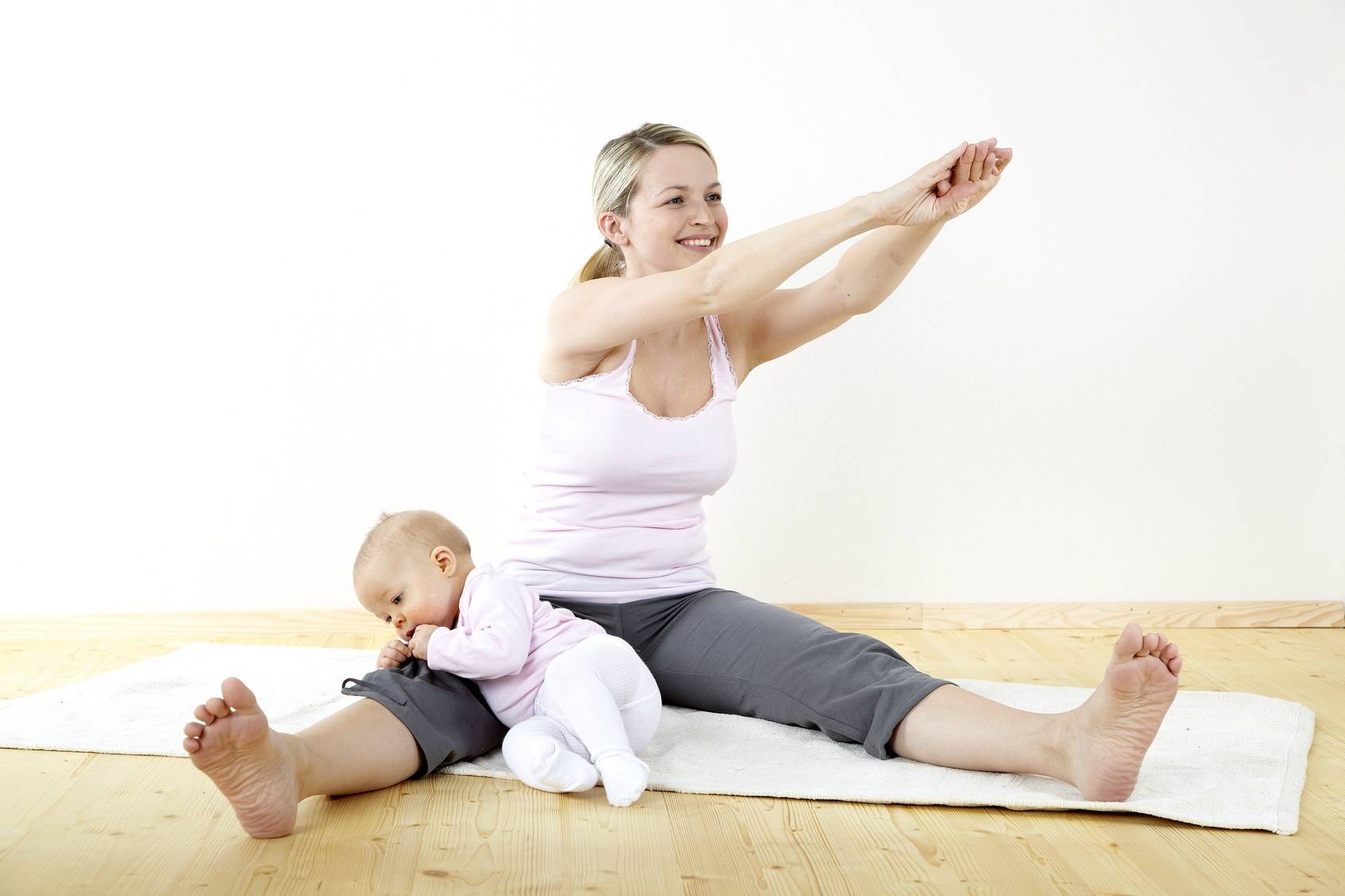 junge mama macht gemeinsam mit ihrem baby fitness und yoga uebungen