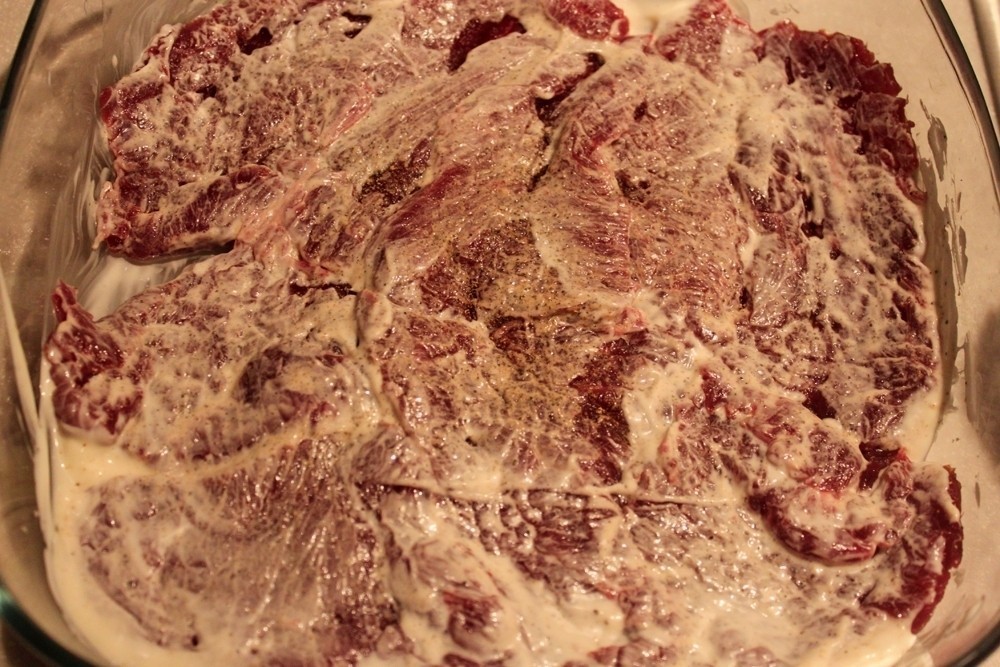 смазанные майонезом сырые кусочки говяжьего мяса в форме